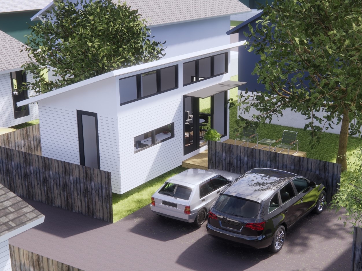 Aerial view of modern white ADU behind existing home with dedicated parking